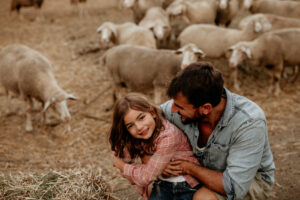 ALTER EGO NOTAIRES - Droit rural - Un père enlace sa fille au milieu de son troupeau de mouton